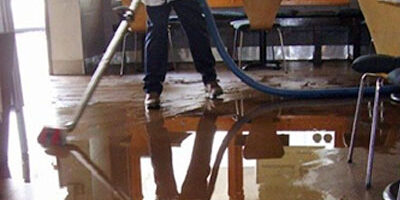 Water Damage Restoration Services – First Choice Restoration Water Damage Restoration in Philadelphoa, Pa - Technician Cleaning Up Water Image